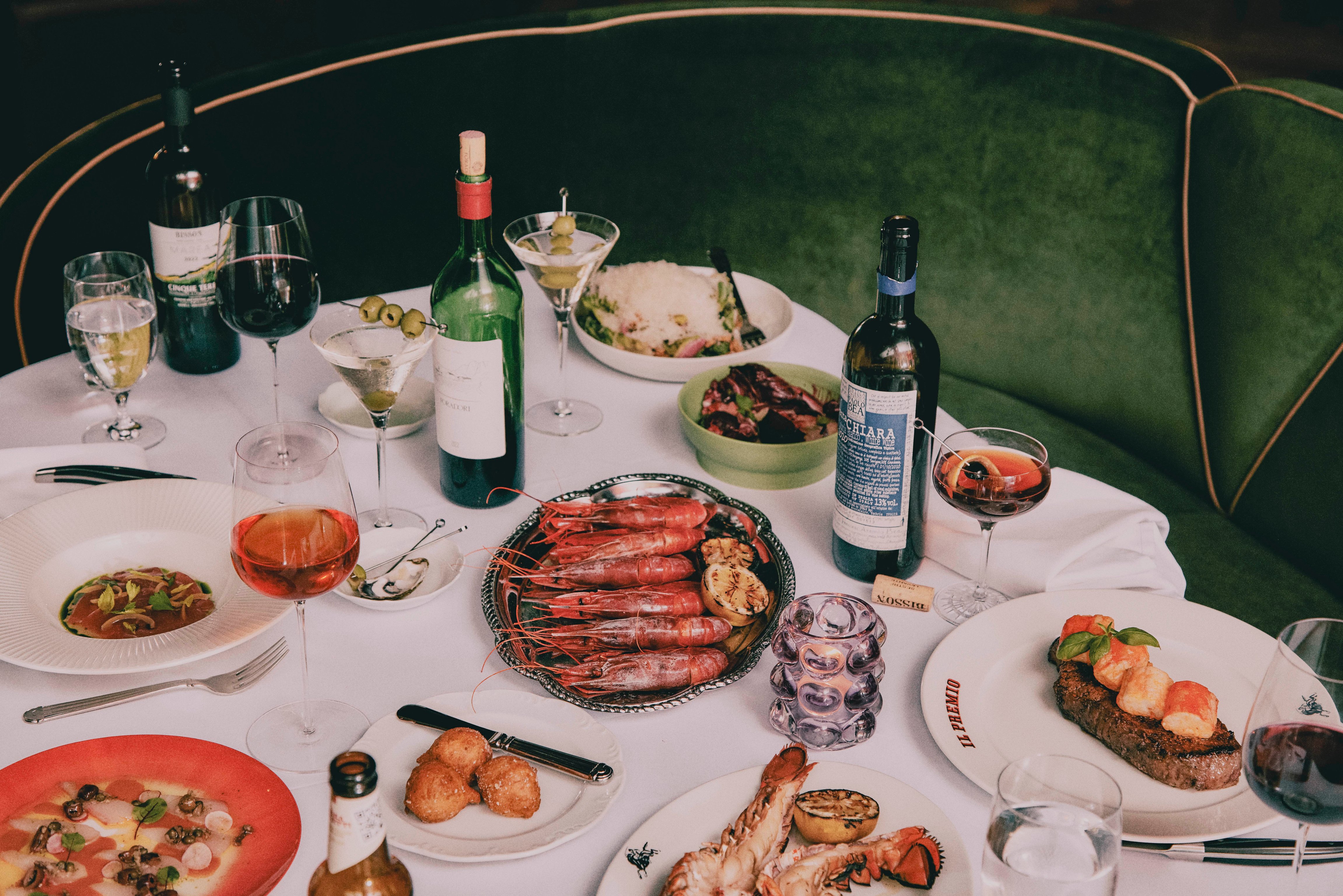 Steak and Italian dishes on a table at Forth Atlanta’s Il Premio