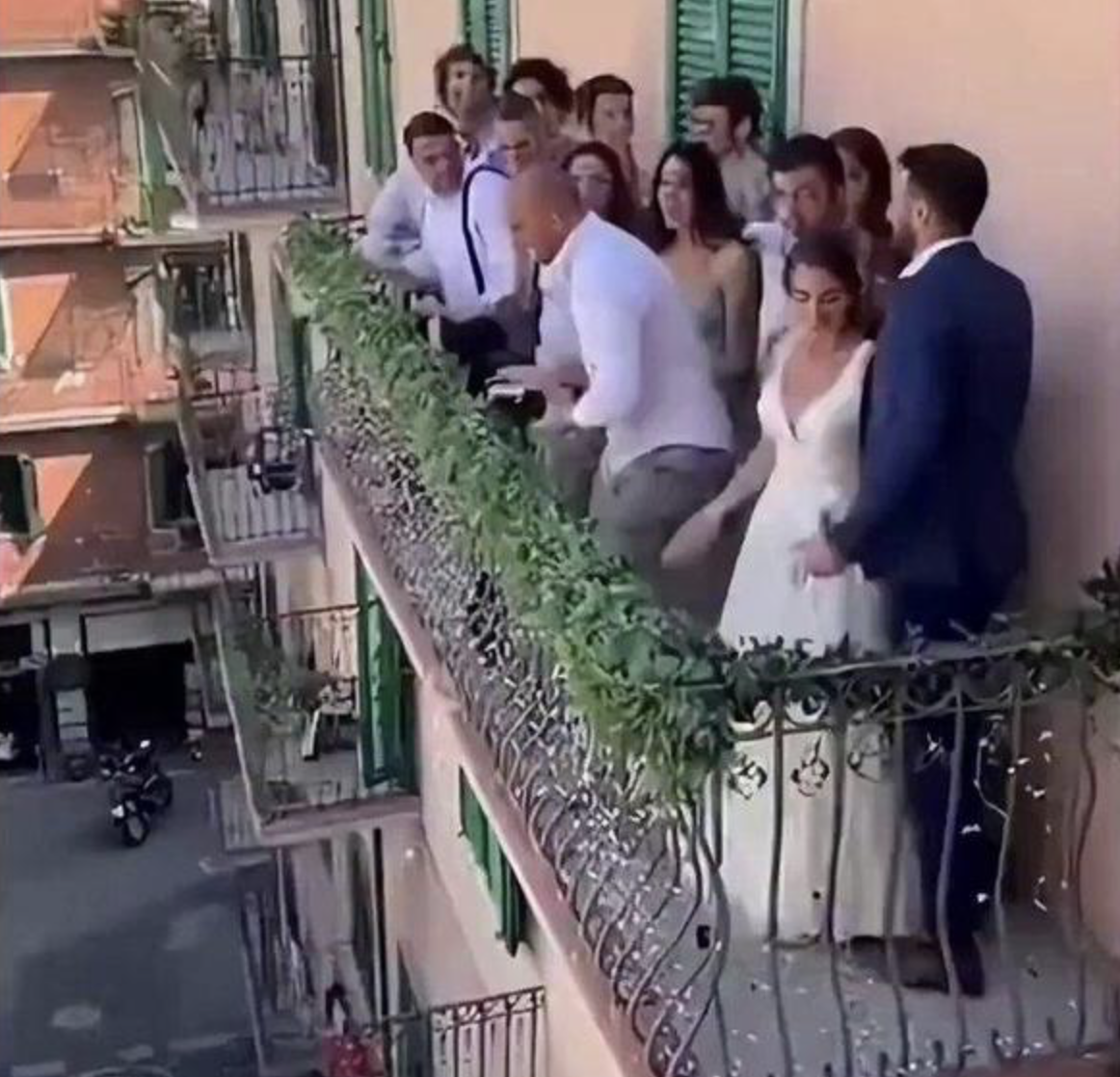 A wedding party frozen mid-fall off a balcony that only ever existed inside a computer