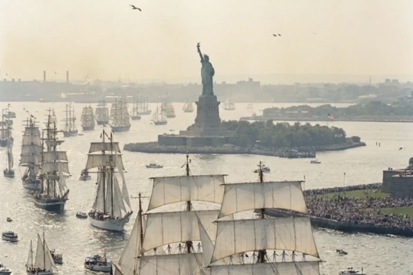 Tall ships gliding past the Statue of Liberty in a parade that only ever sailed through AI