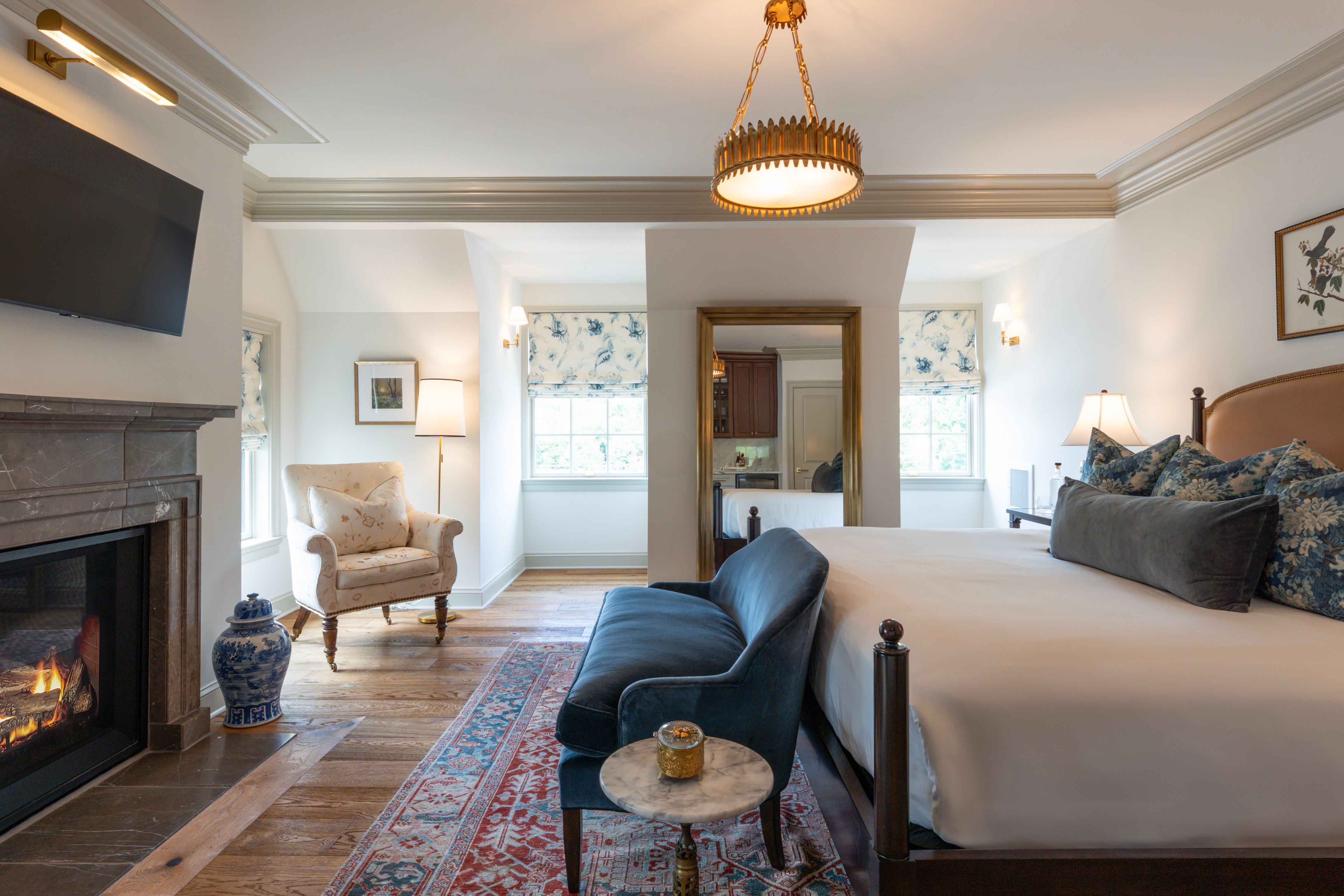 Hotel Burg guest room with a fireplace, sitting area, patterned rug, and upholstered bed