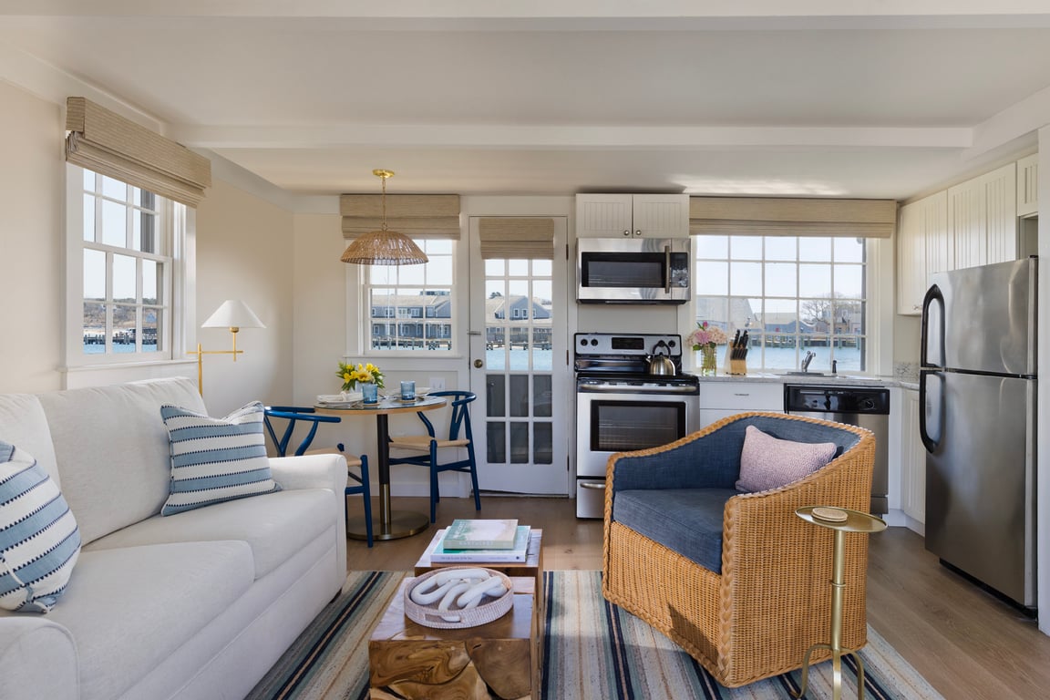 Open-plan cottage living room and full kitchen with harbor views