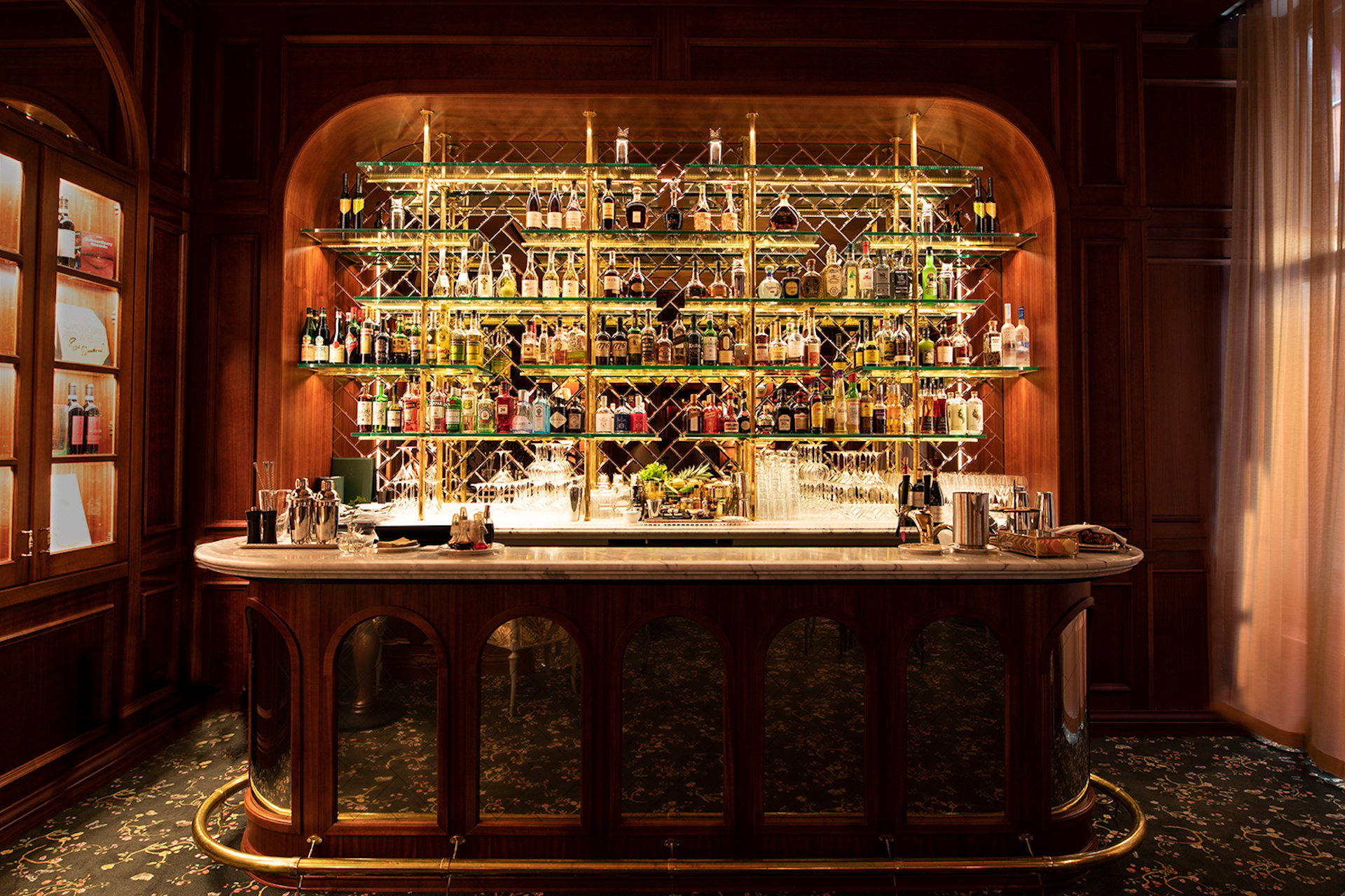 Intimate wood-paneled bar with a glowing bottle display