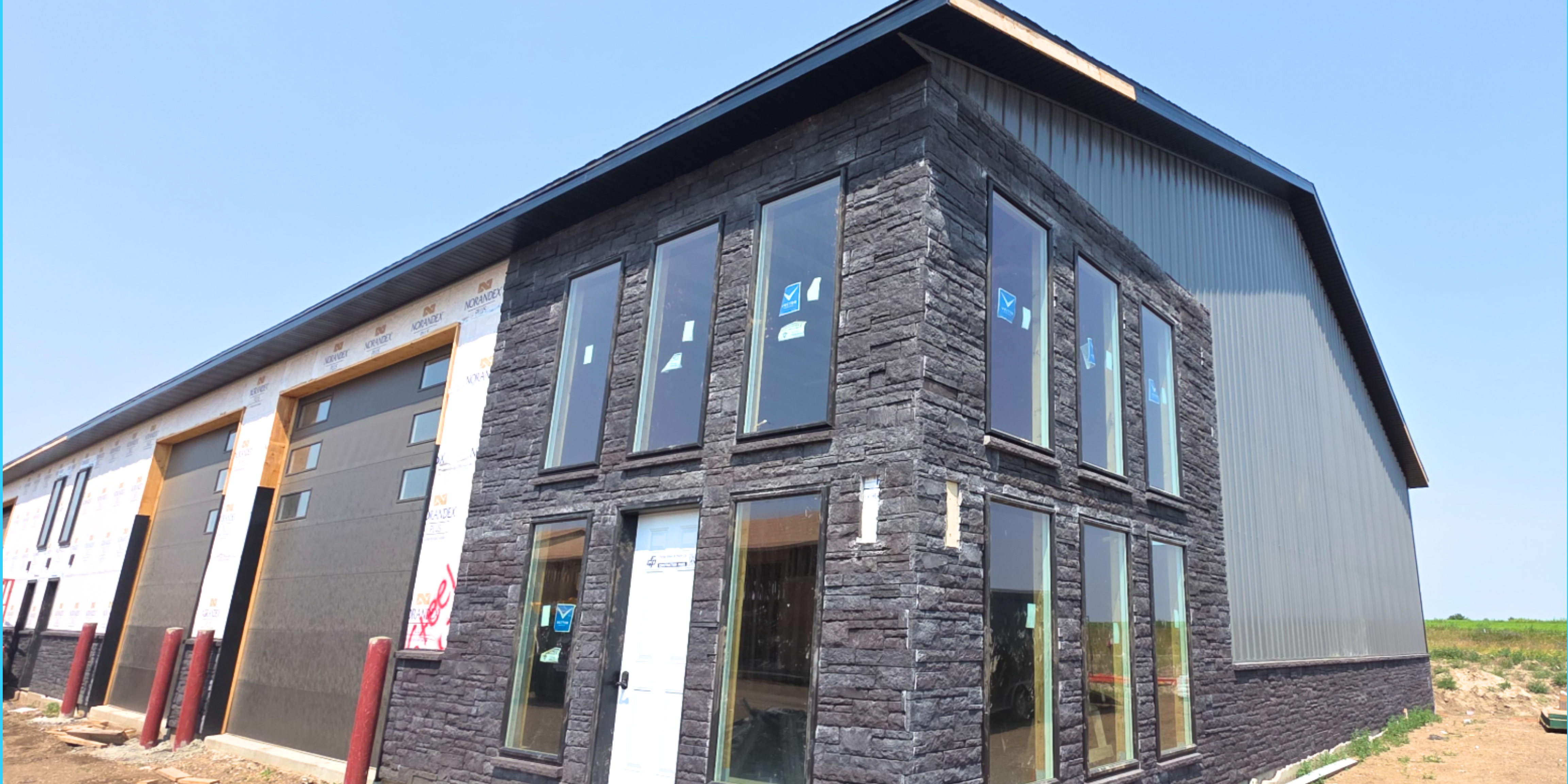 Completed Williston Shop Condos building with steel siding, stone wainscot and overhead doors at 313 60th Ave W in Williston, North Dakota