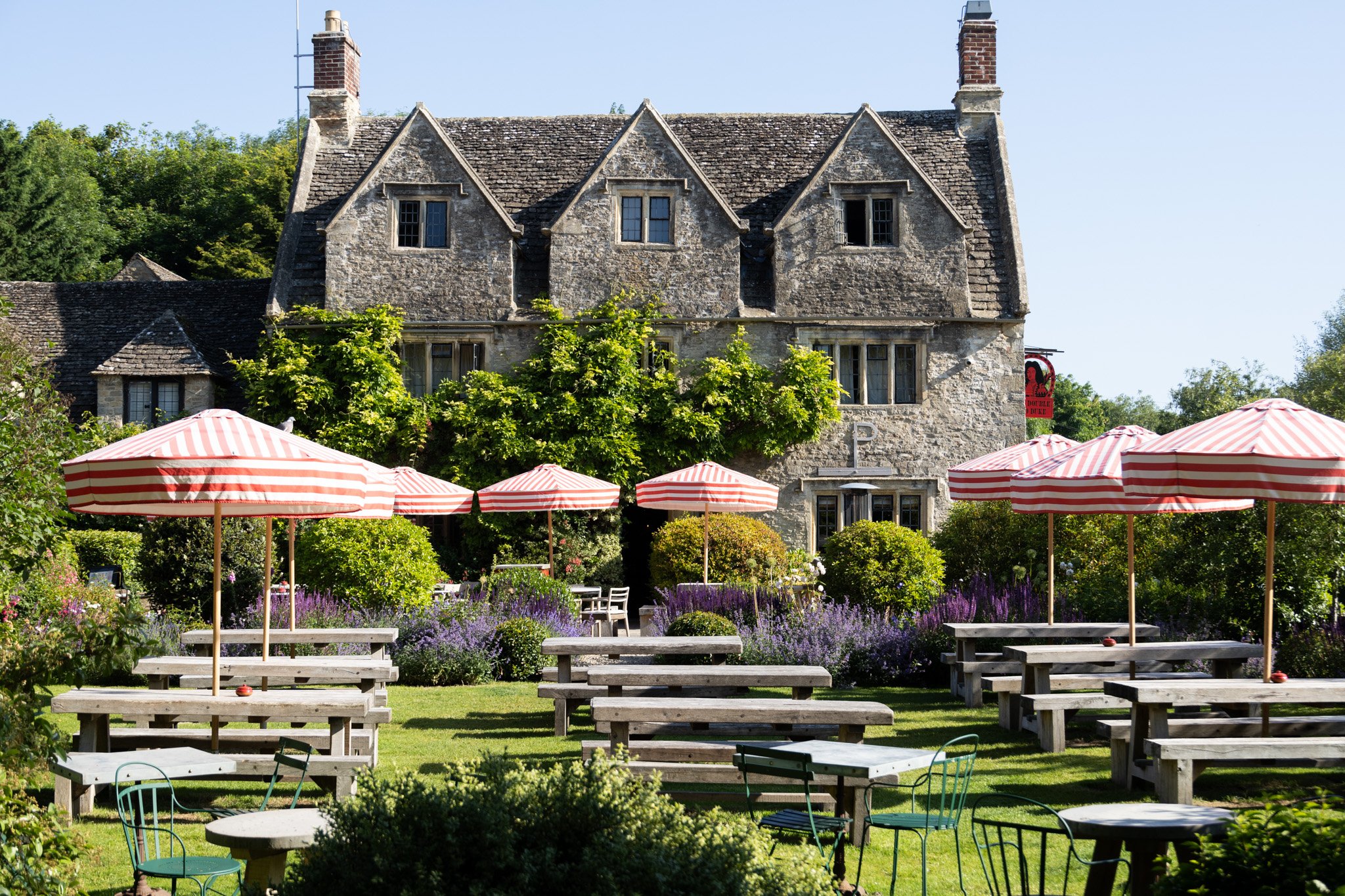 Stone façade and striped garden umbrellas at The Double Red Duke