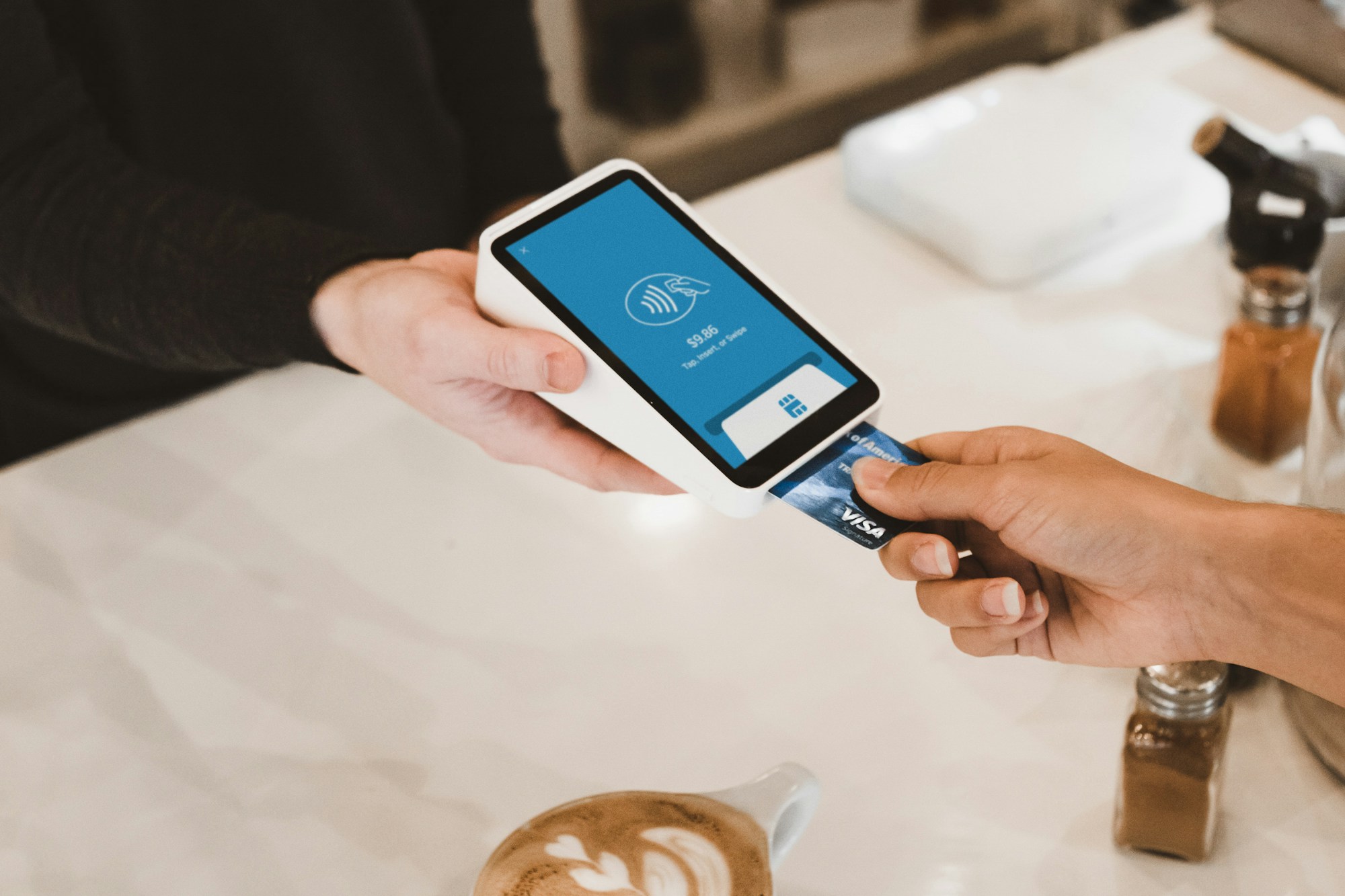 Person inserting a credit card into a payment terminal