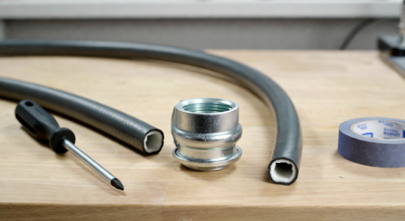 Garden hose on a workbench with a hose mender, screwdriver, and clean cut hose ends