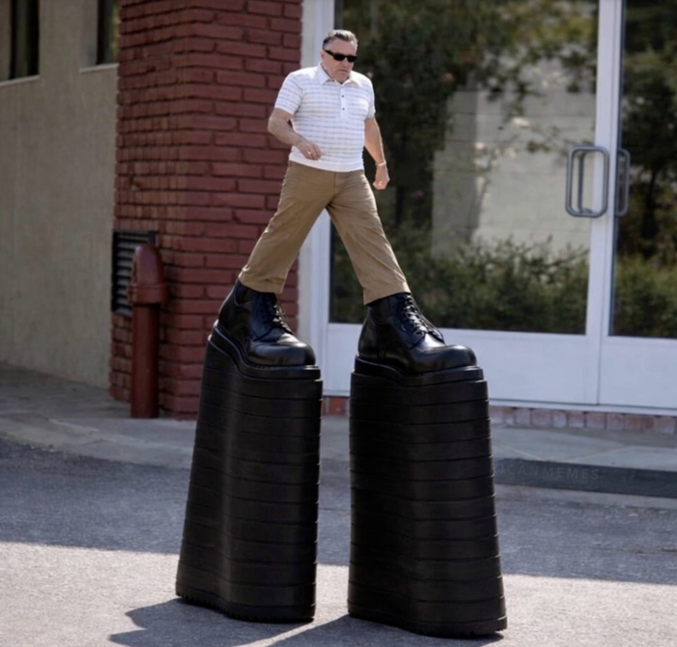 Robert De Niro striding down a sidewalk in comically tall platform boots, one of them splitting into pieces mid-step