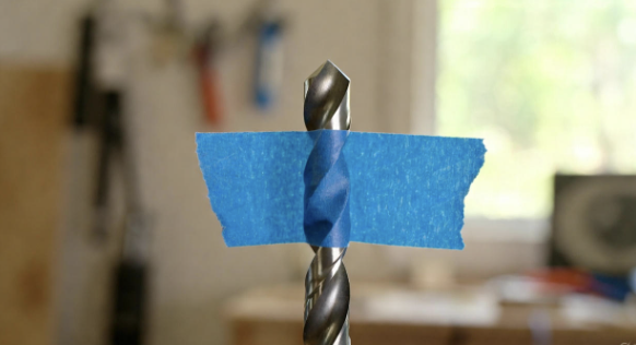Drill bit with a piece of tape wrapped around it as a depth marker
