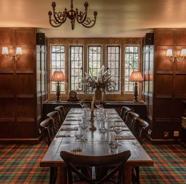 Wood-paneled dining room with a long set table