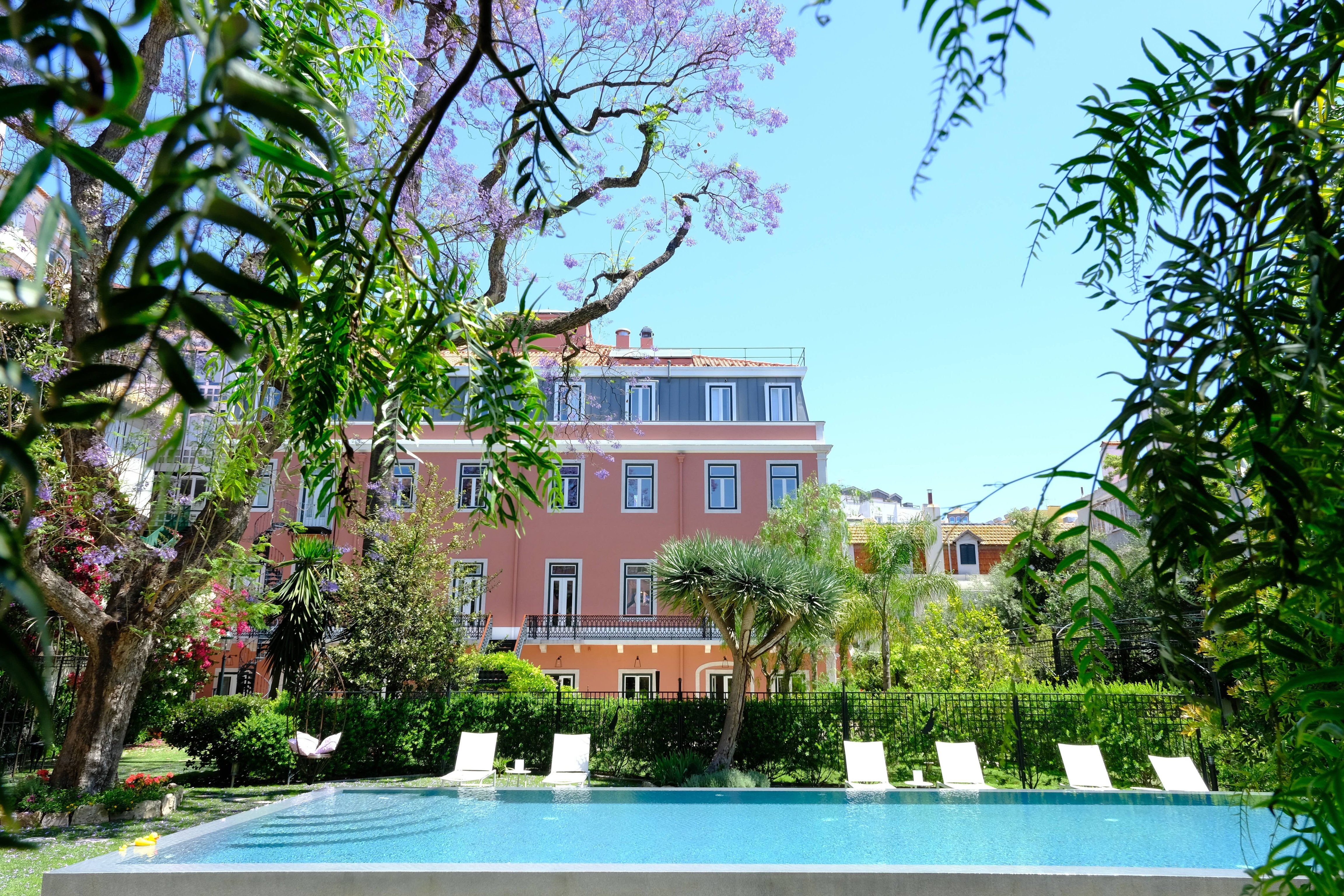 Palácio Príncipe Real garden and saltwater pool framed by trees and flowering plants