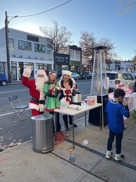 Santa and helpers at a sidewalk table during an earlier Port Holiday Magic celebration.