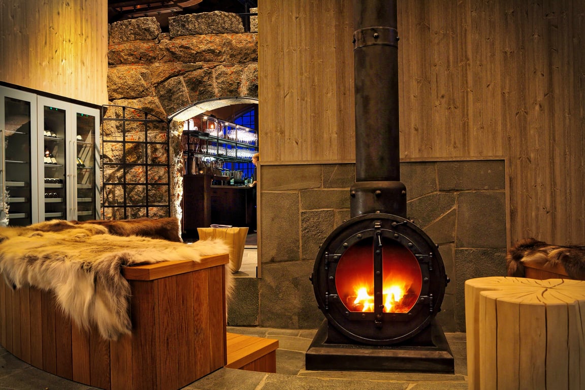 Suspended fireplace and timber interiors at Niehku Mountain Villa