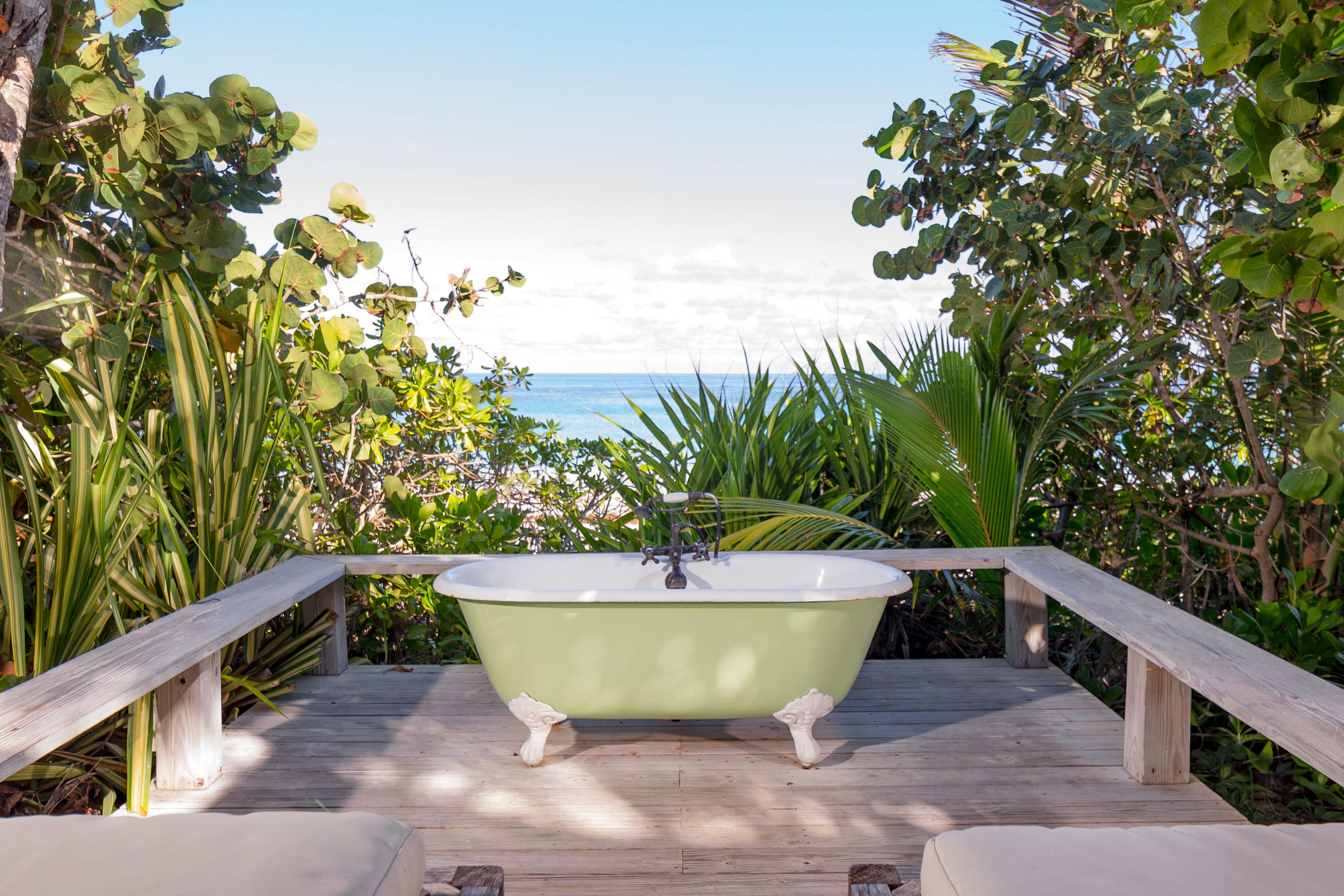 Green outdoor clawfoot bathtub overlooking the sea at The Ocean View Club