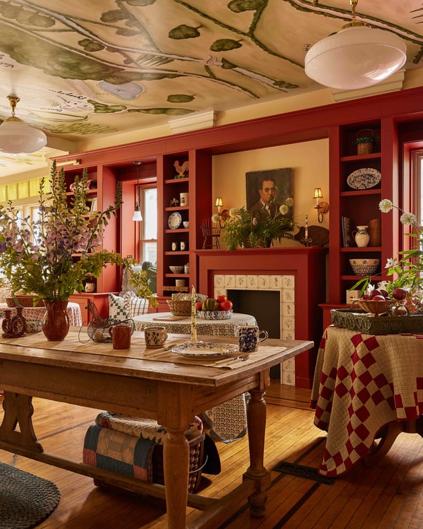 Painted ceiling, red shelves and a wooden display table in the lobby of The Six Bells Countryside Inn.