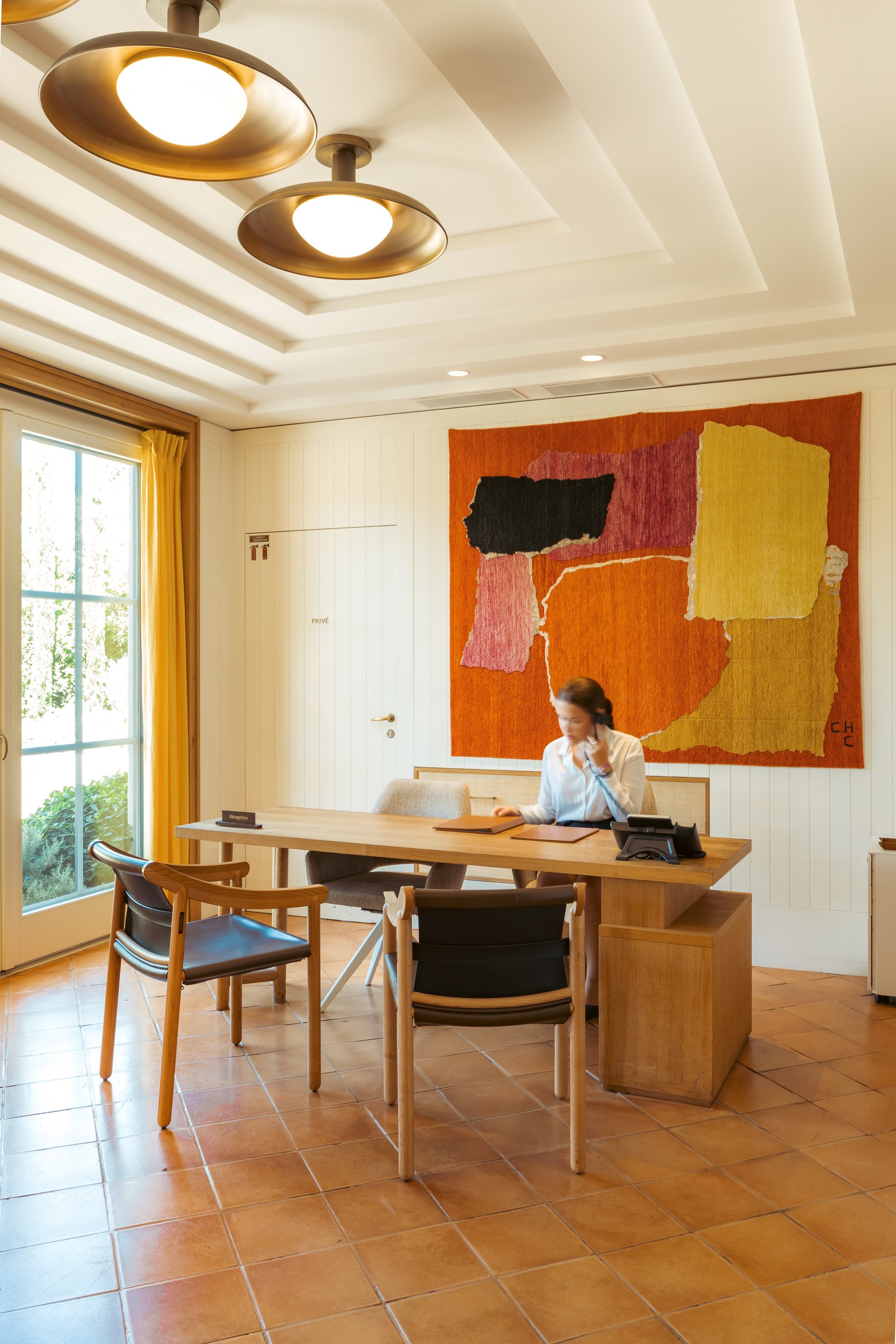 Colorful artwork and reception desk at Hôtel Lou Pinet