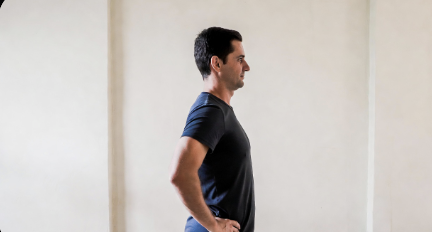 Man standing tall with hands on hips doing a gentle back reset