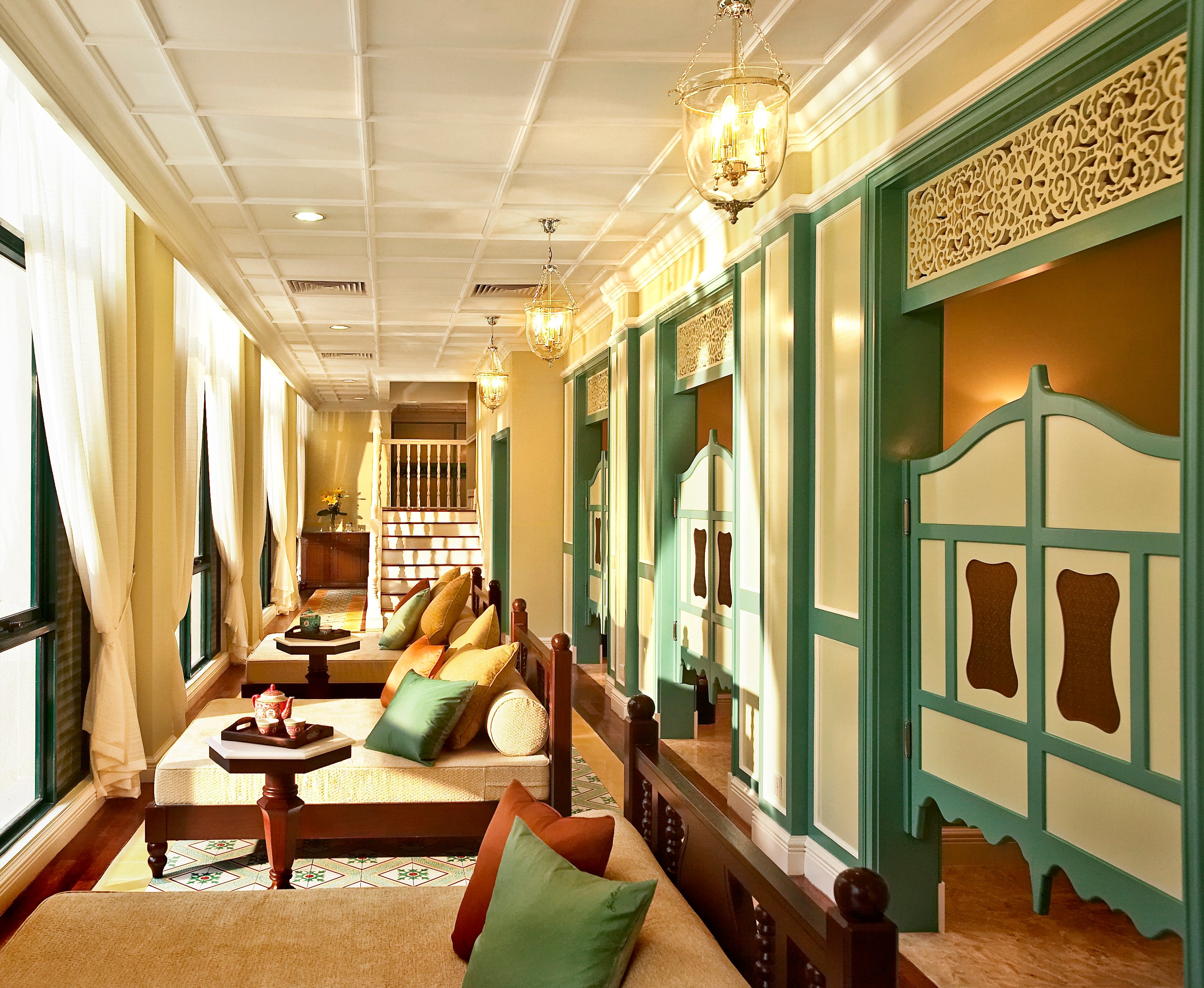 Sunlit heritage corridor with turquoise doors at The Majestic Malacca