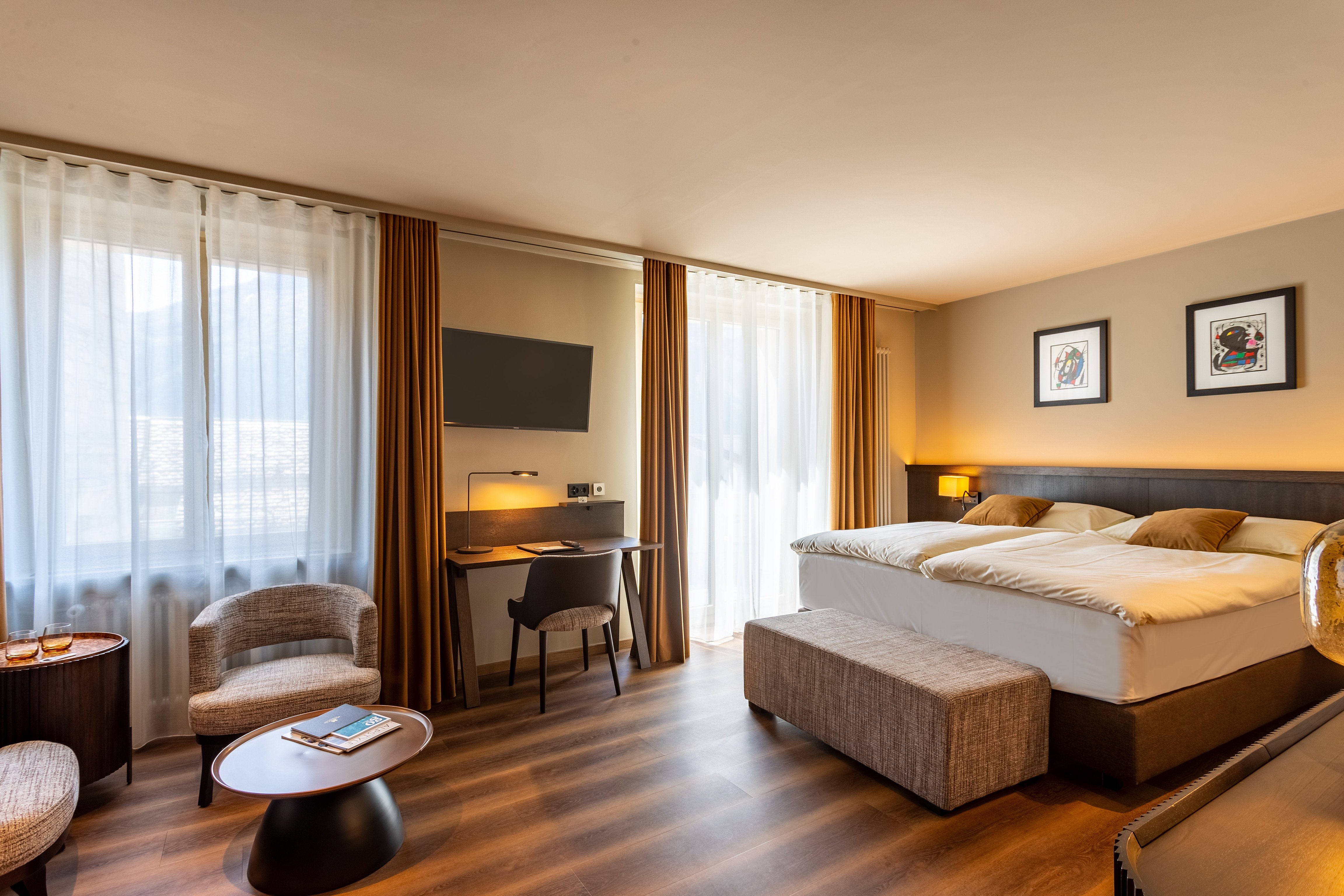 Spacious bedroom and desk beside large windows at Art Boutique Hotel Monopol