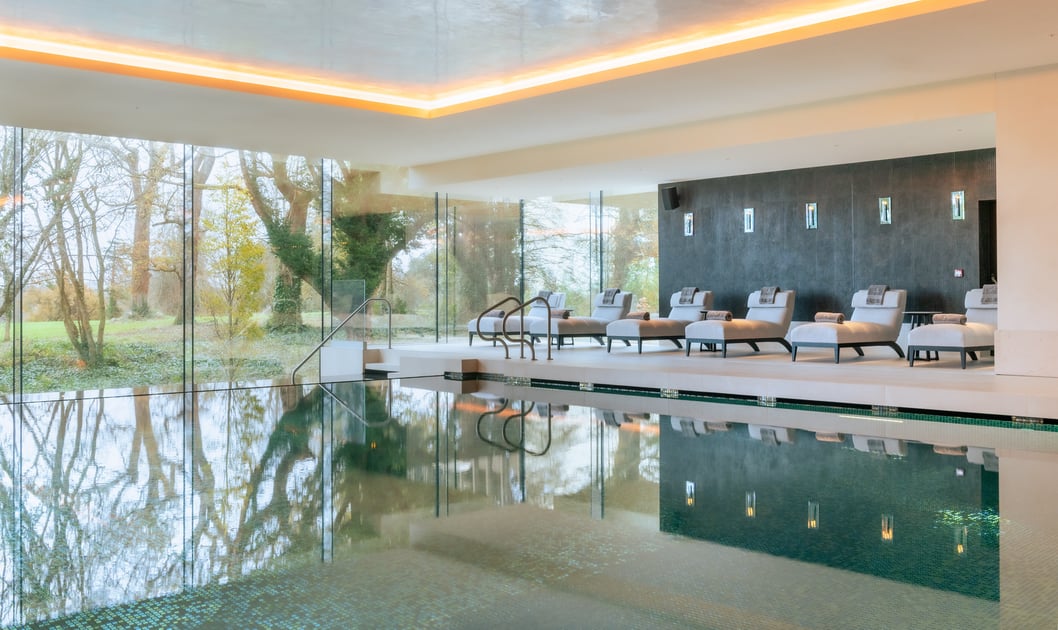 Indoor swimming pool with floor-to-ceiling windows at Adare Manor