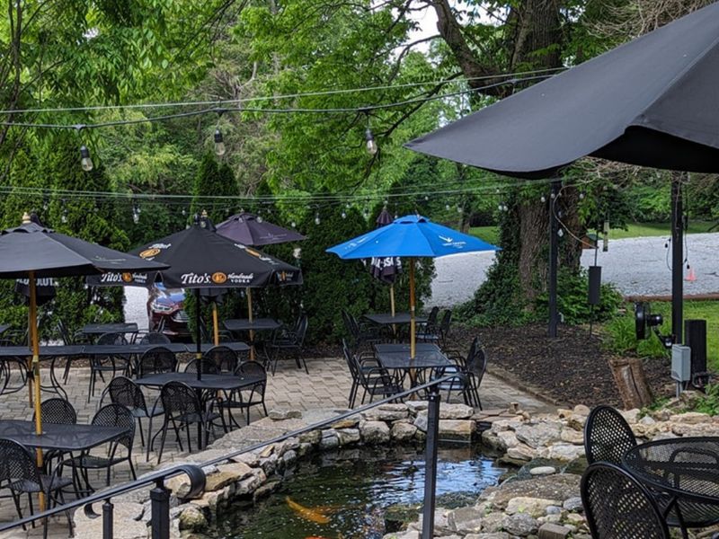 Stone patio beside a koi pond under the trees at Selena's
