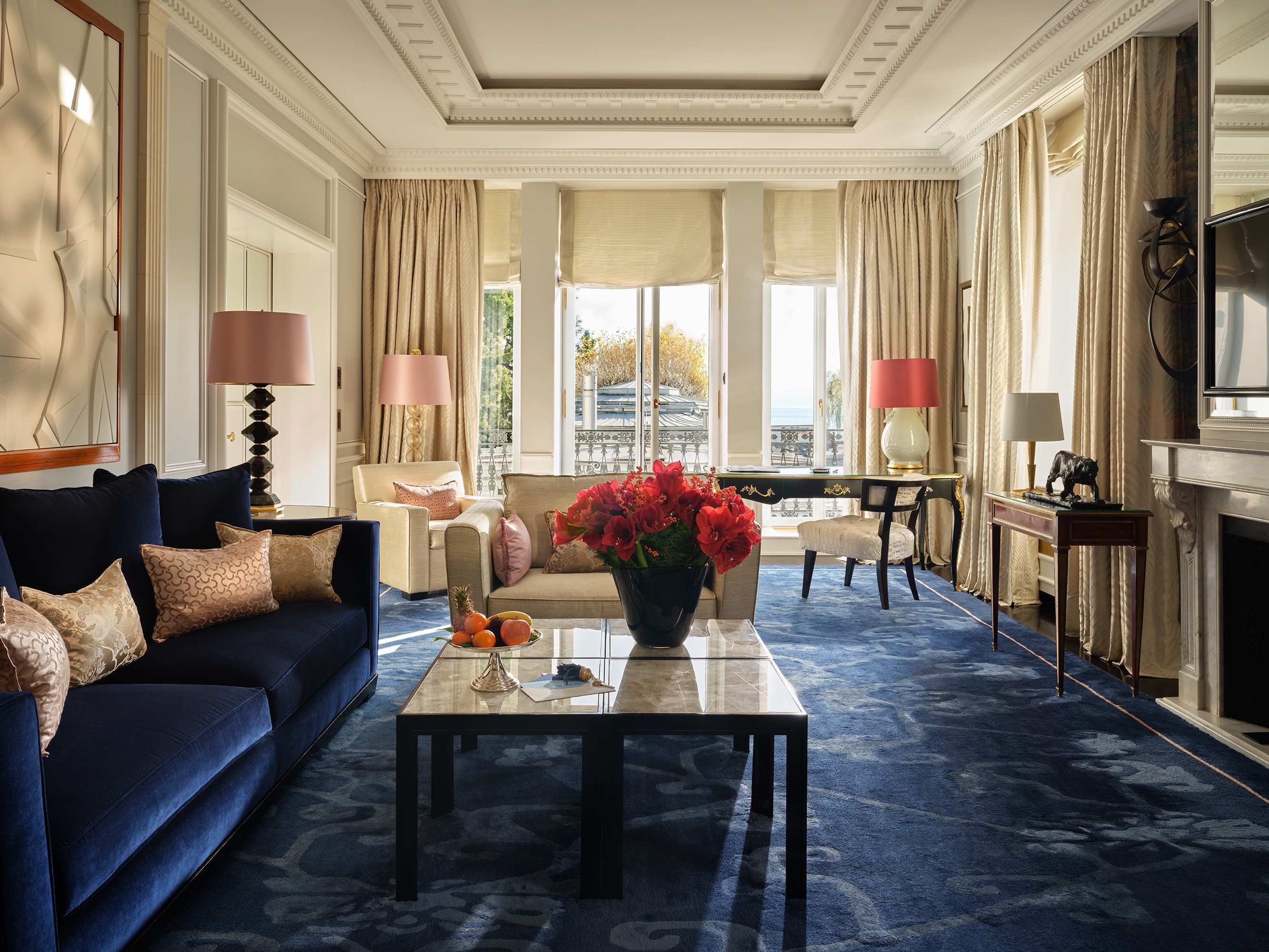 Spacious Baur au Lac suite with a blue sofa and lake-facing windows