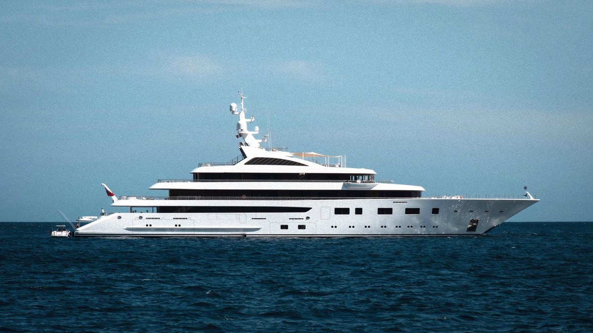 A large superyacht anchored in a tropical bay