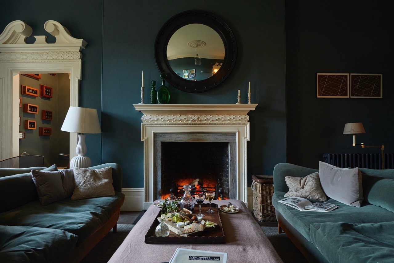 Cozy dark-painted lounge with an open fireplace