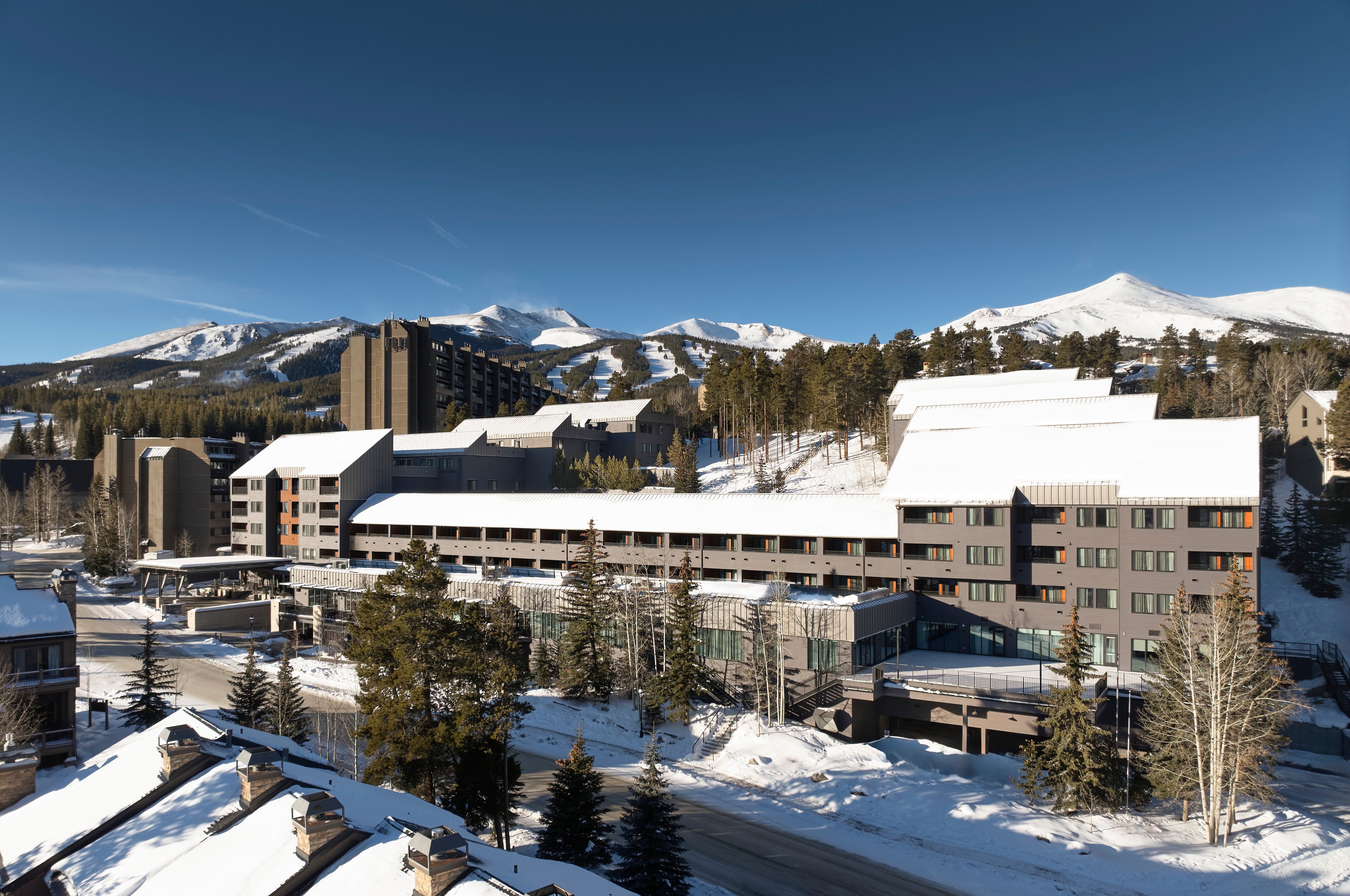 Snow-covered Hotel Alpenrock Breckenridge with mountains beyond