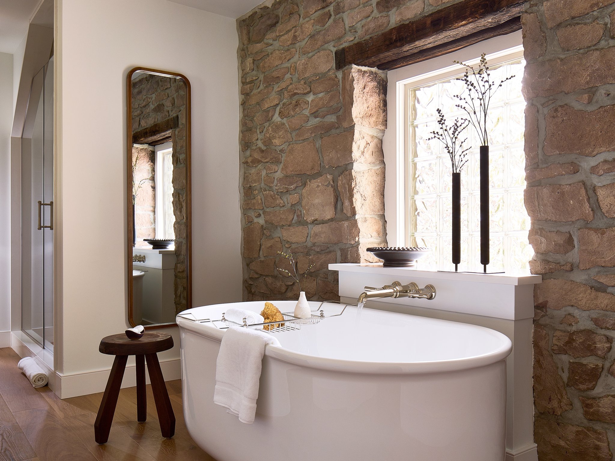 Freestanding bathtub beside exposed stone walls at Stockton Inn