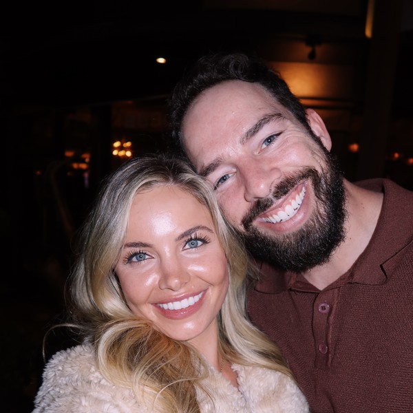 Adam and a friend smiling cheek to cheek on a night out
