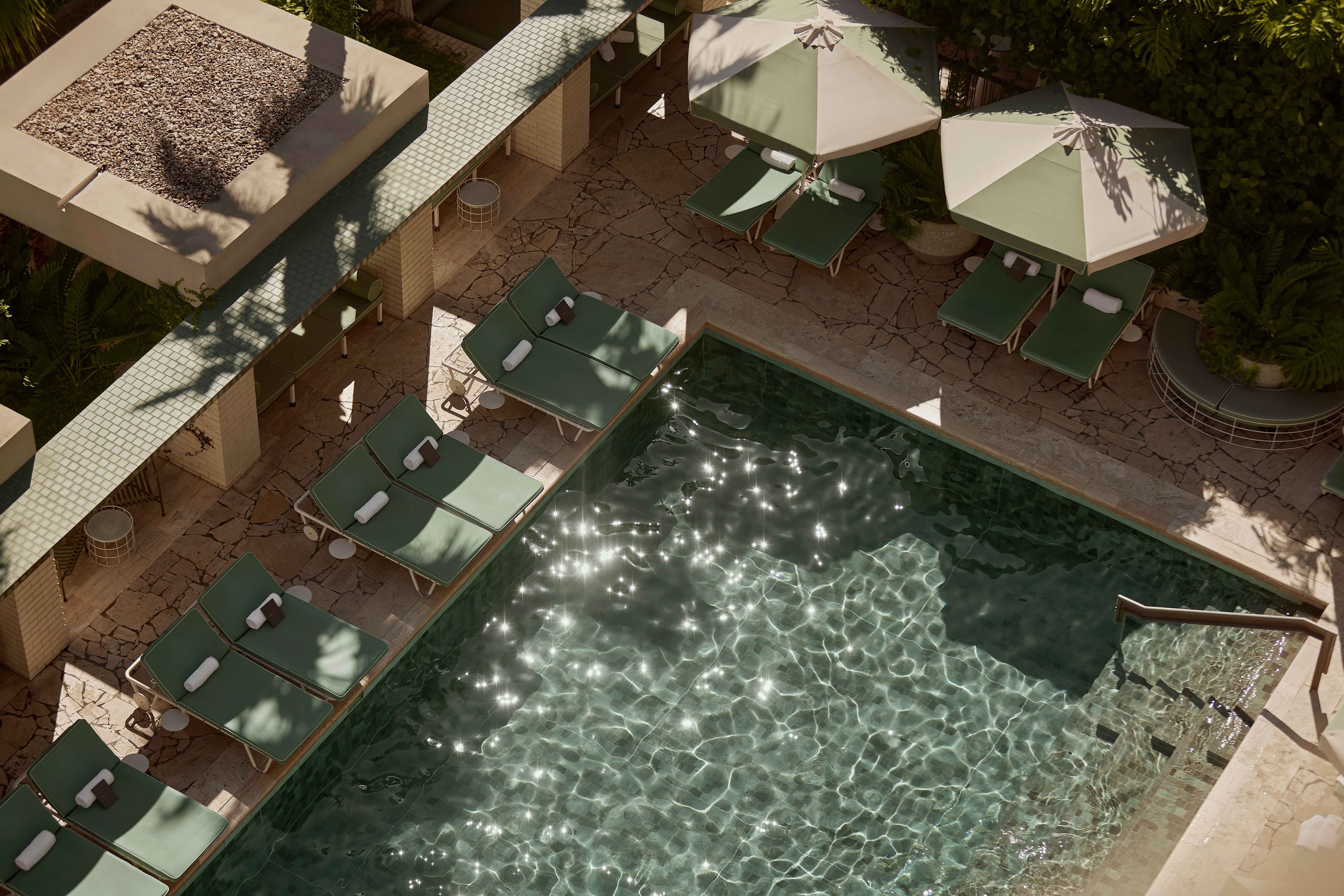 Pool terrace with green umbrellas and cabanas