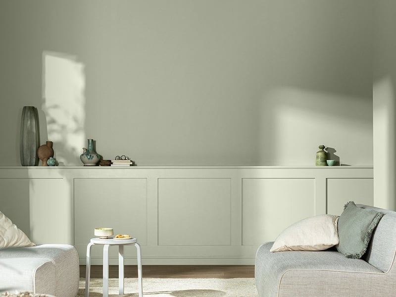 Dulux’s Soulful Sage roomset, with pale green walls and panelling and light upholstered seating.