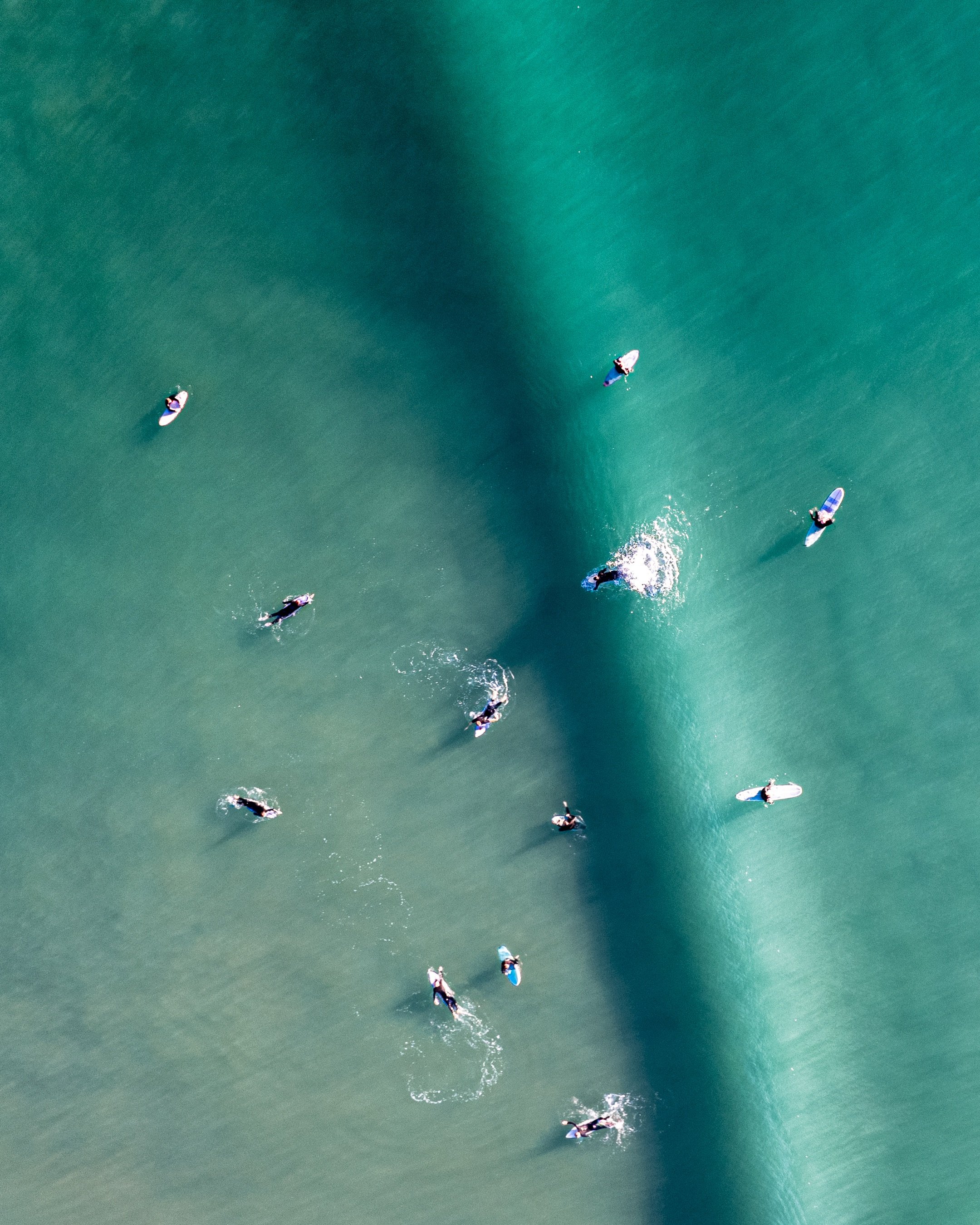 Aerial view of surfers waiting in turquoise ocean water