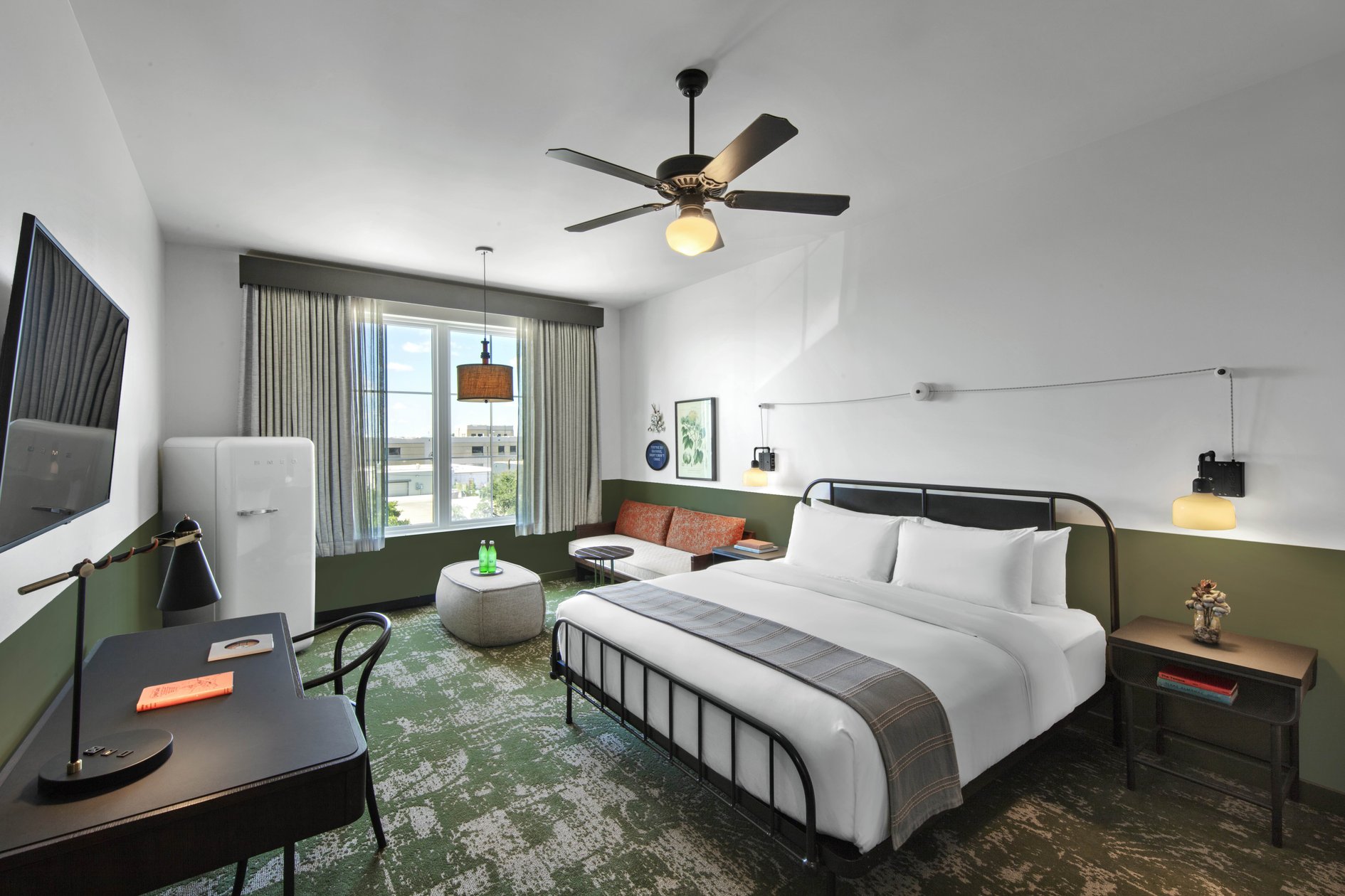 Cotton Court Hotel guest room with an iron bed and cotton-field patterned carpet