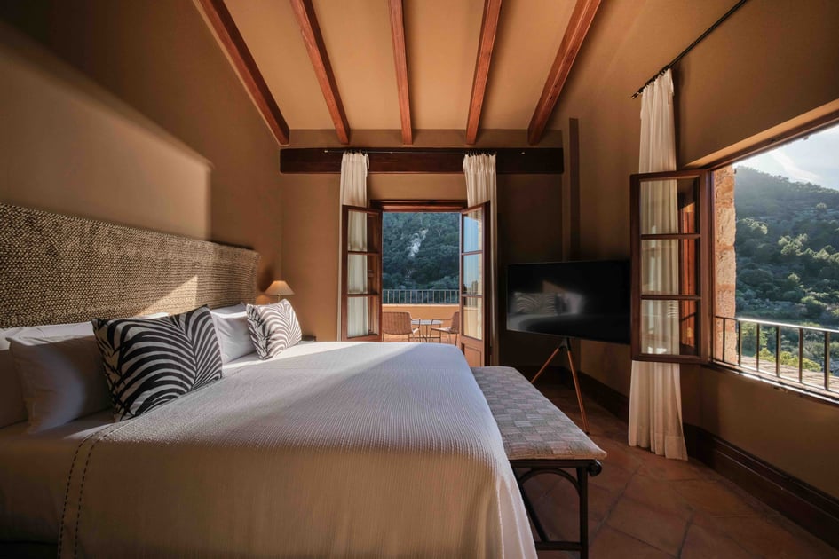 Guest room with wood beams and mountain views at Hotel Valldemossa