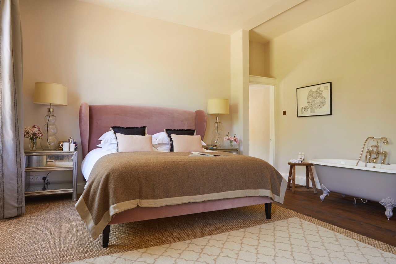 Quiet guest room with a pink upholstered headboard