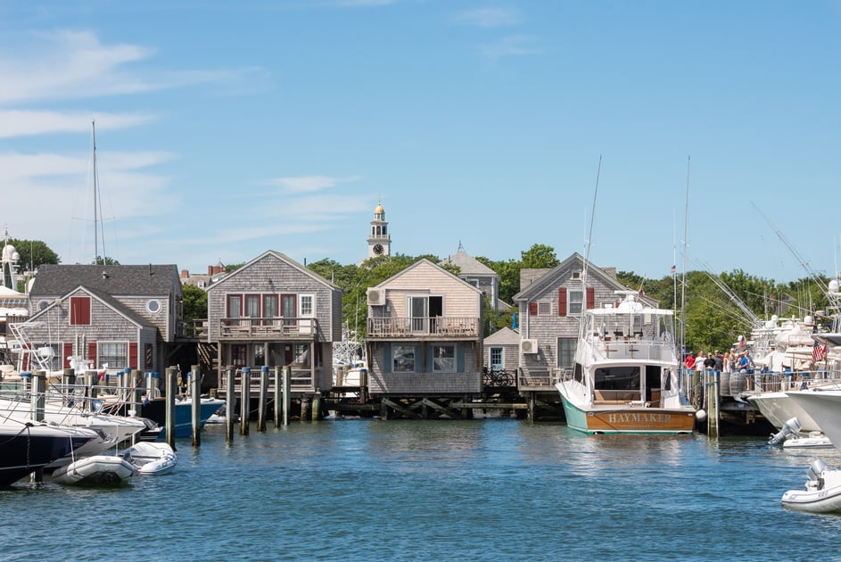 Nantucket Boat Basin cottages, boats, and harbor beneath a blue sky