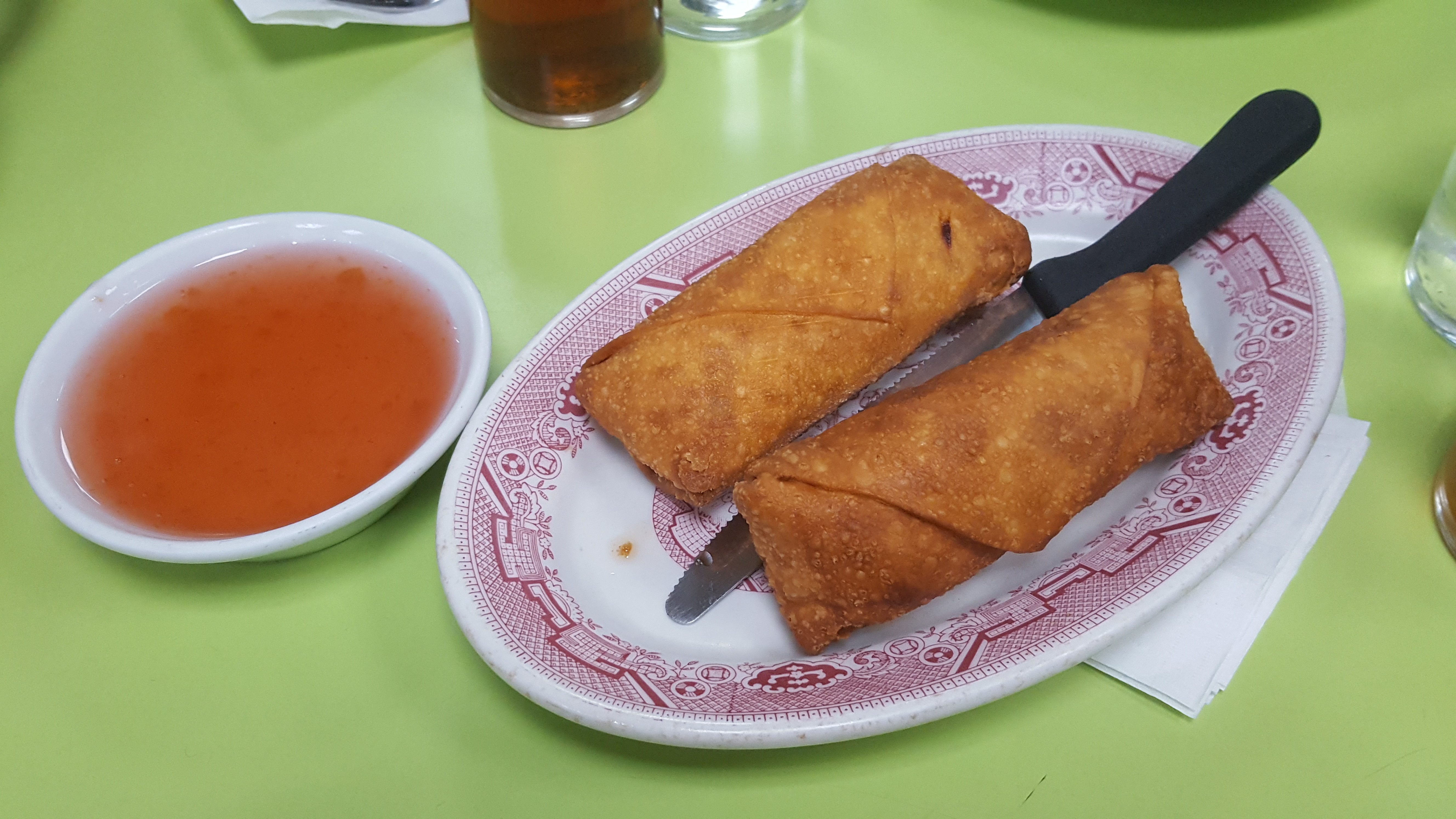 Two fried egg rolls and a dish of duck sauce on the willow-pattern plate at Wo Hop, 17 Mott Street.