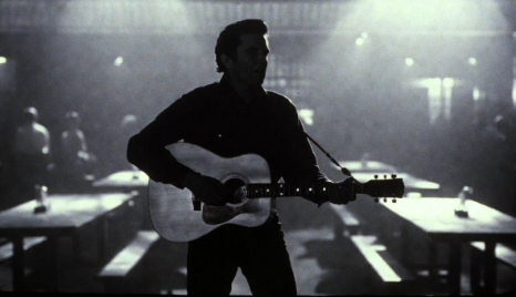 Johnny Cash performing with guitar in a prison setting