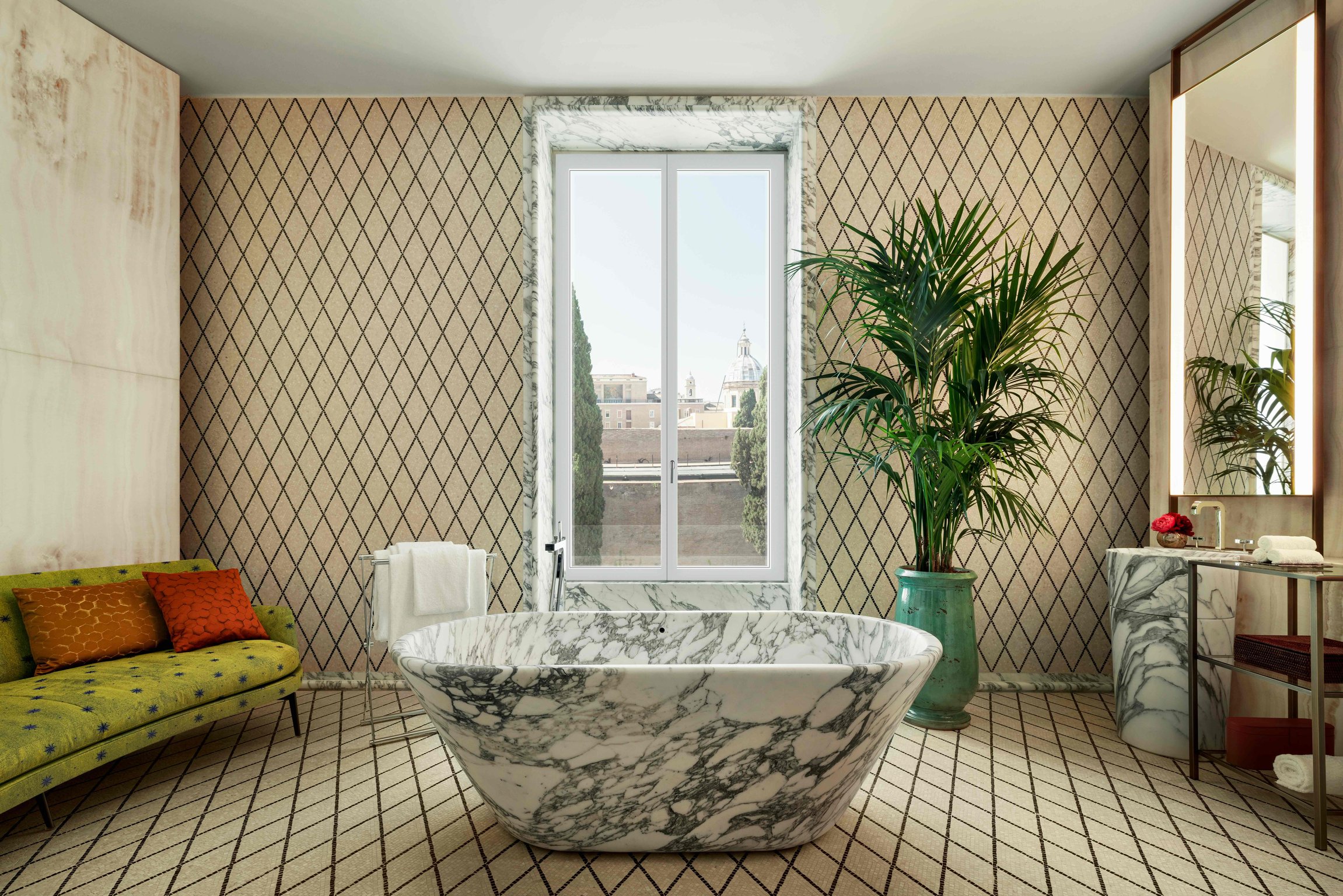 Freestanding marble bathtub beside a window at Bvlgari Hotel Roma