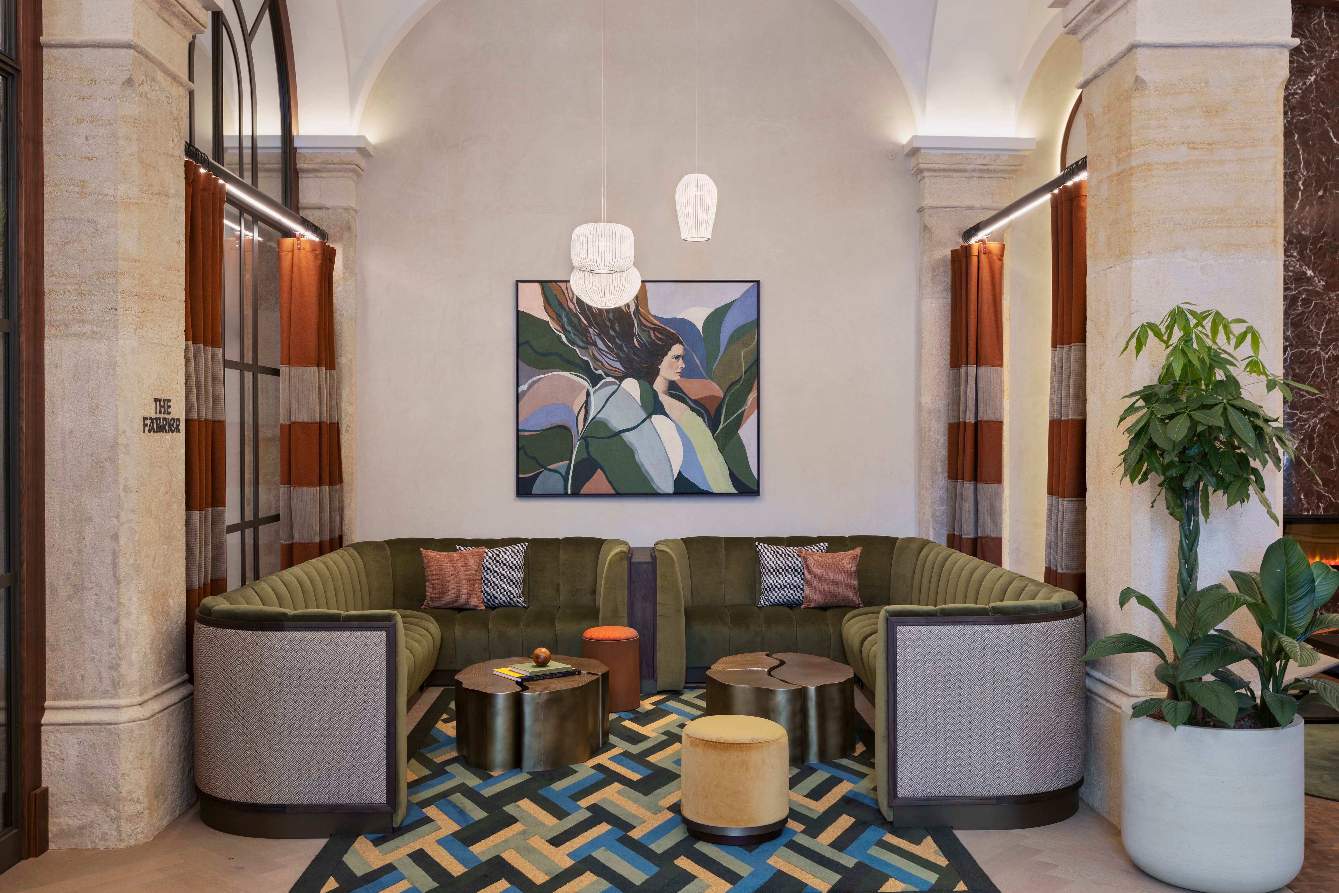 Sage-green lounge seating between stone pillars at the Imperial Riding School