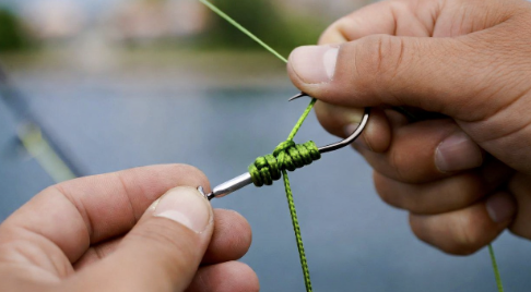 Close up of fishing line being tied to a hook