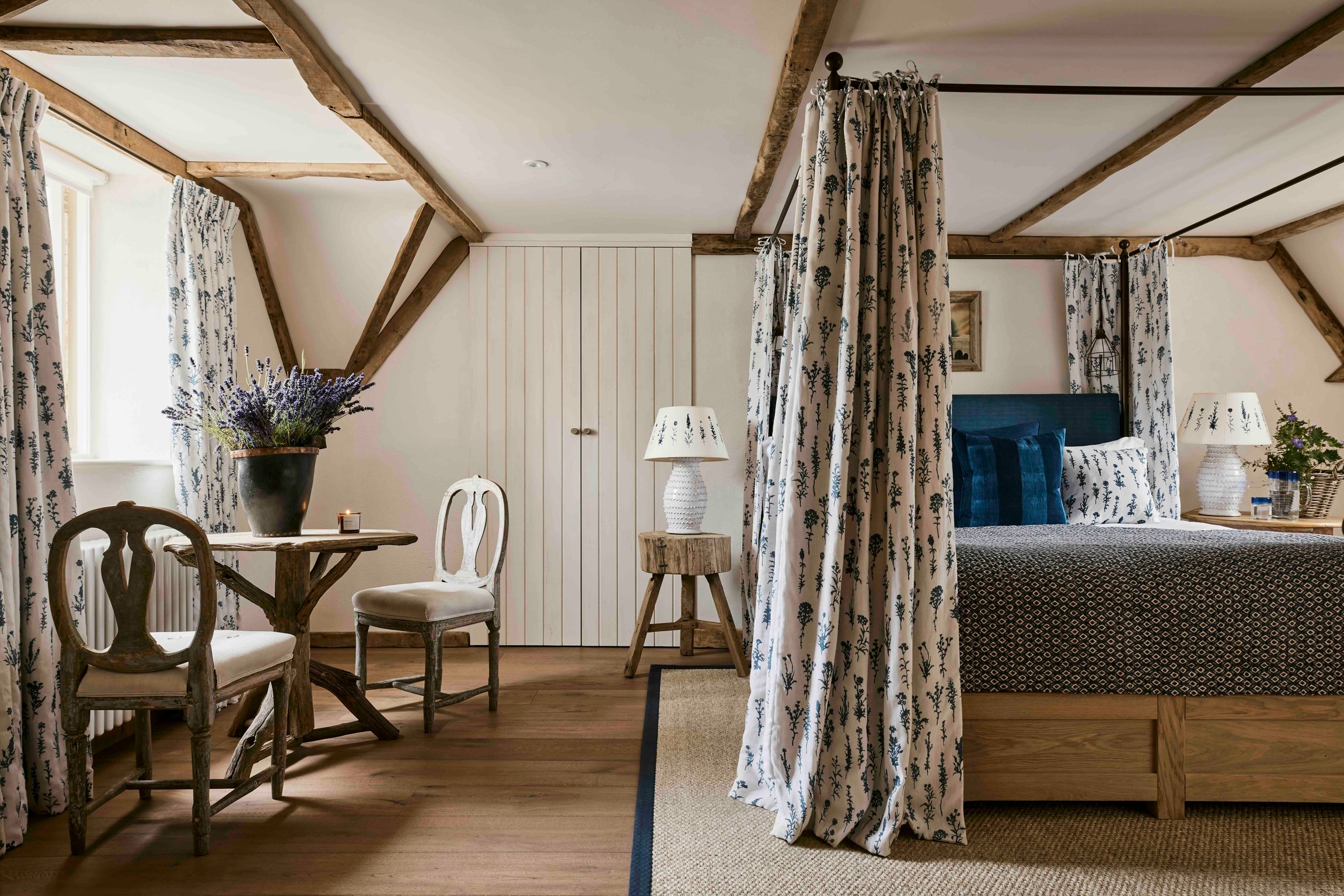 Curtained bed and exposed beams in a room at The Fox at Oddington