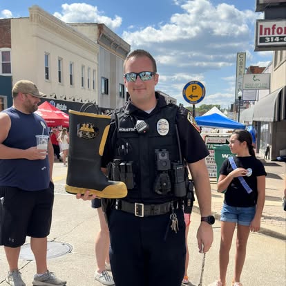 A local first responder holds a donation boot for BackStoppers of Jefferson County