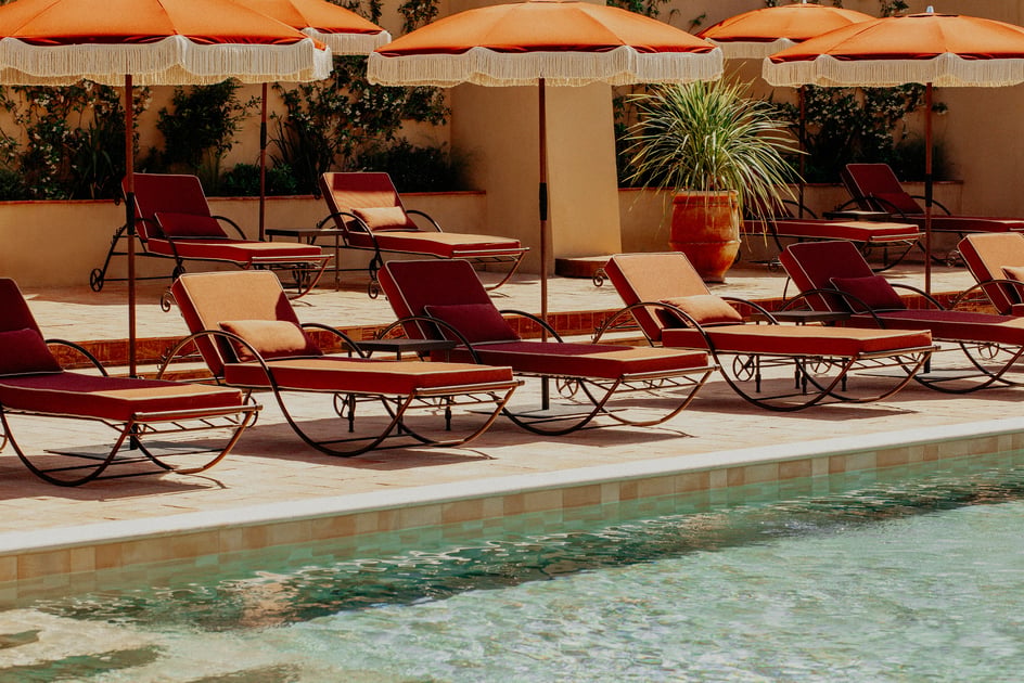 Retro loungers and terracotta umbrellas beside the pool