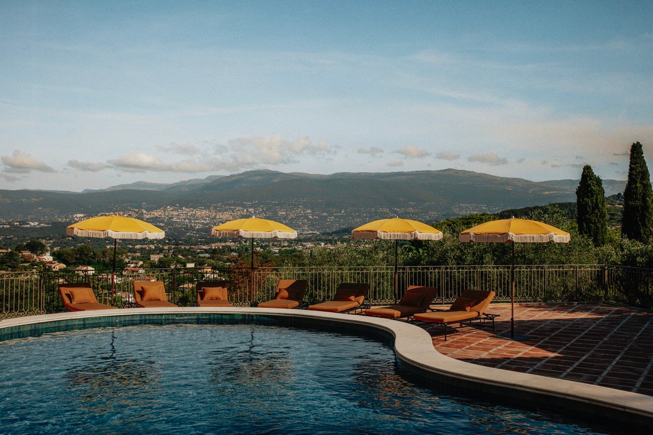 Outdoor pool and yellow umbrellas overlooking the Provençal hills