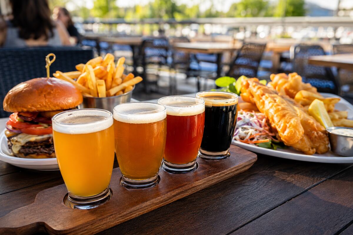 Craft beer flight with burger, fries and fish and chips on a sunny brewpub patio table